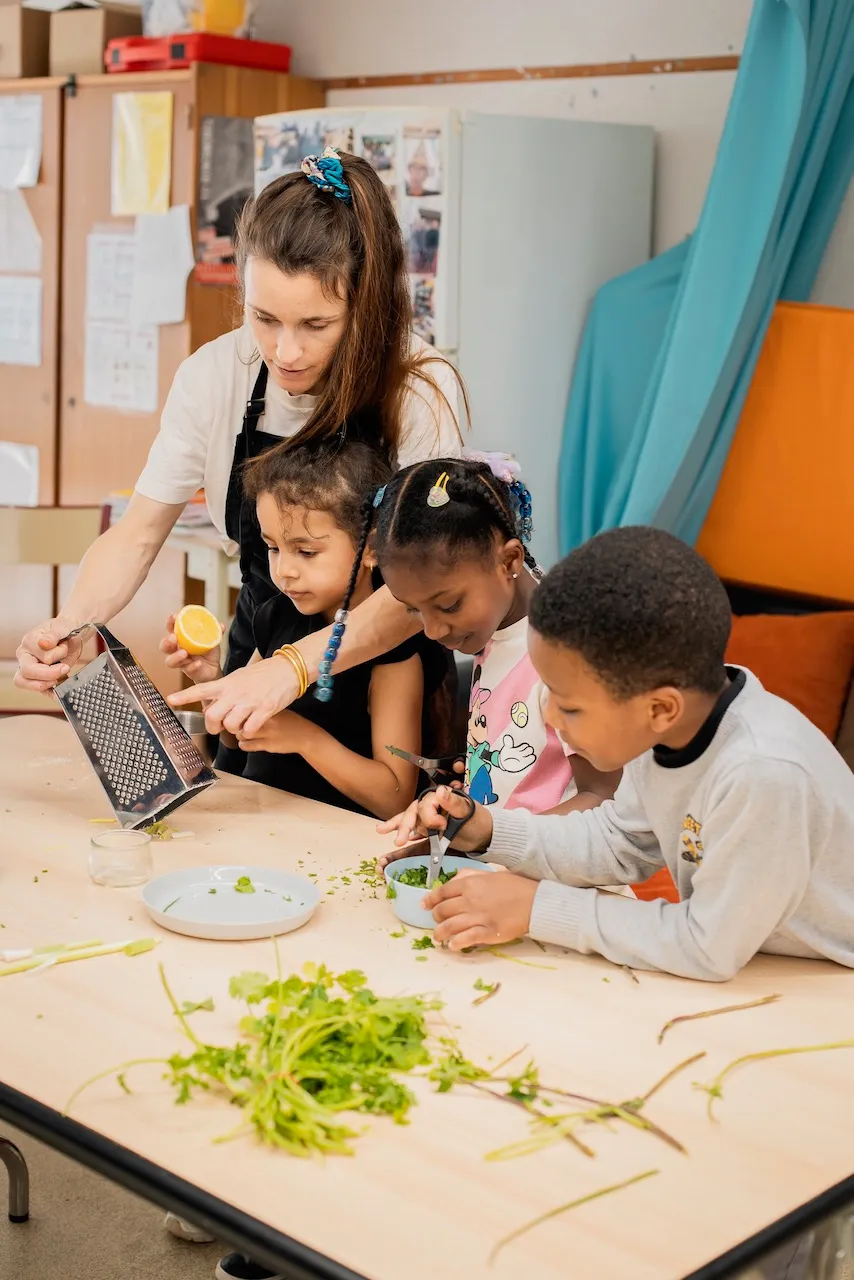 Enfants préparent des légumes pendant un atelier comestible
