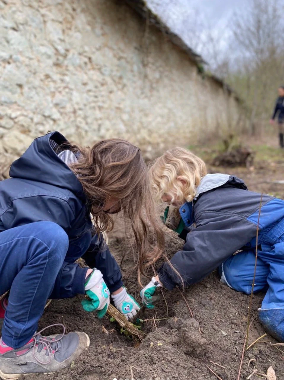 Deux enfants plantants des semis durant une session à l'école les petites ruches