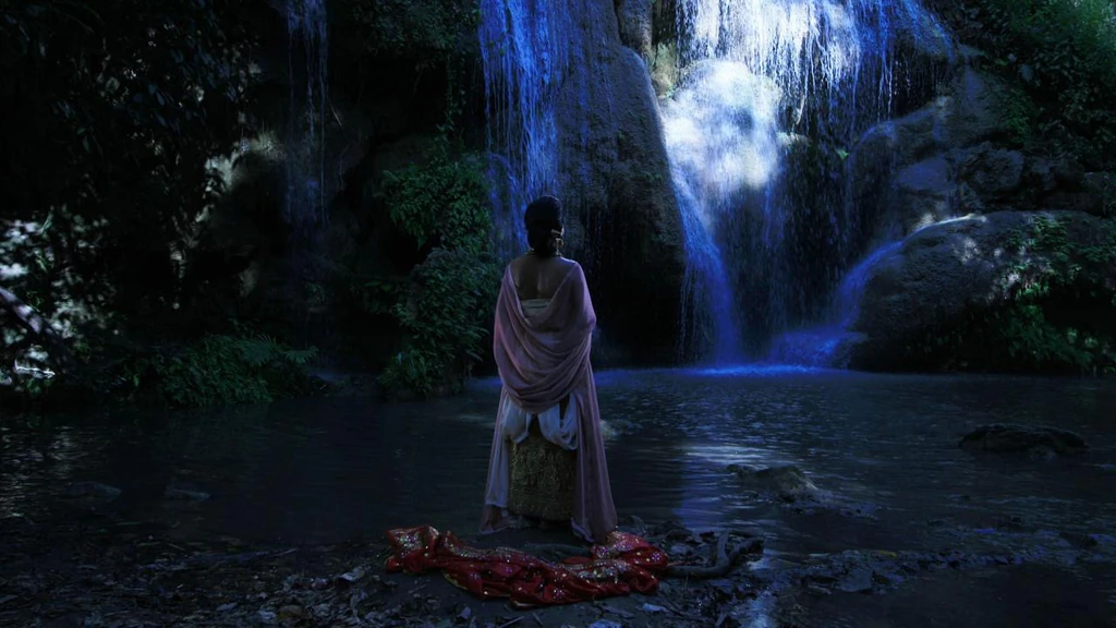 Femme devant un lac et cascade dans une atmosphère onirique