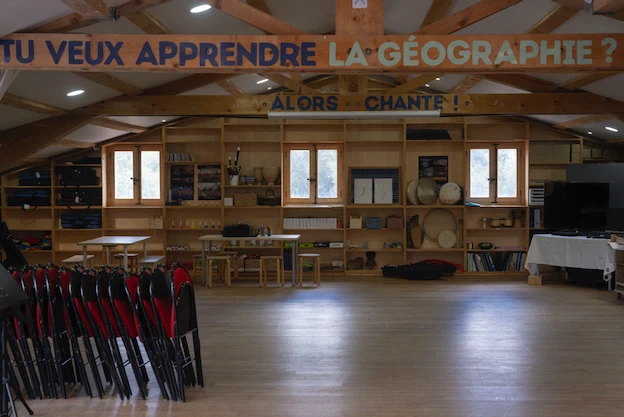 Grande salle commune en parquet et poutres apparentes
