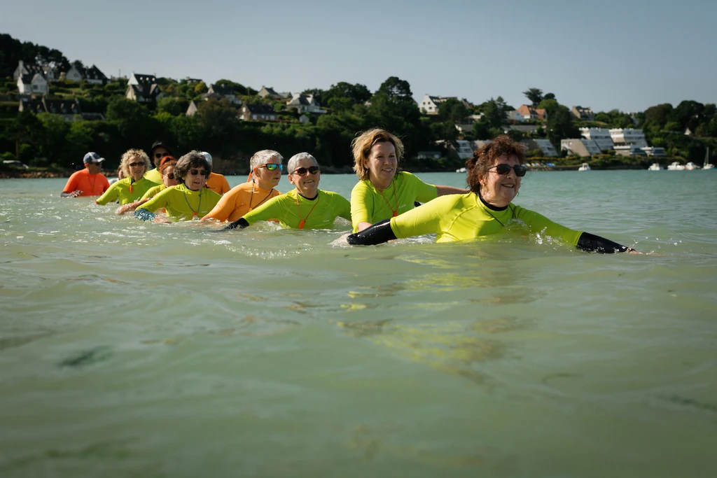 Pratiquantes de longe-côte avancent en rang serré dans l'eau