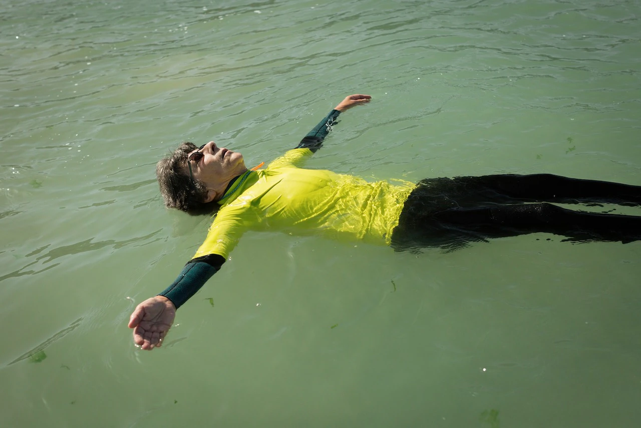 Une femme en combinaison Néoprène, fait la planche dans l'eau 