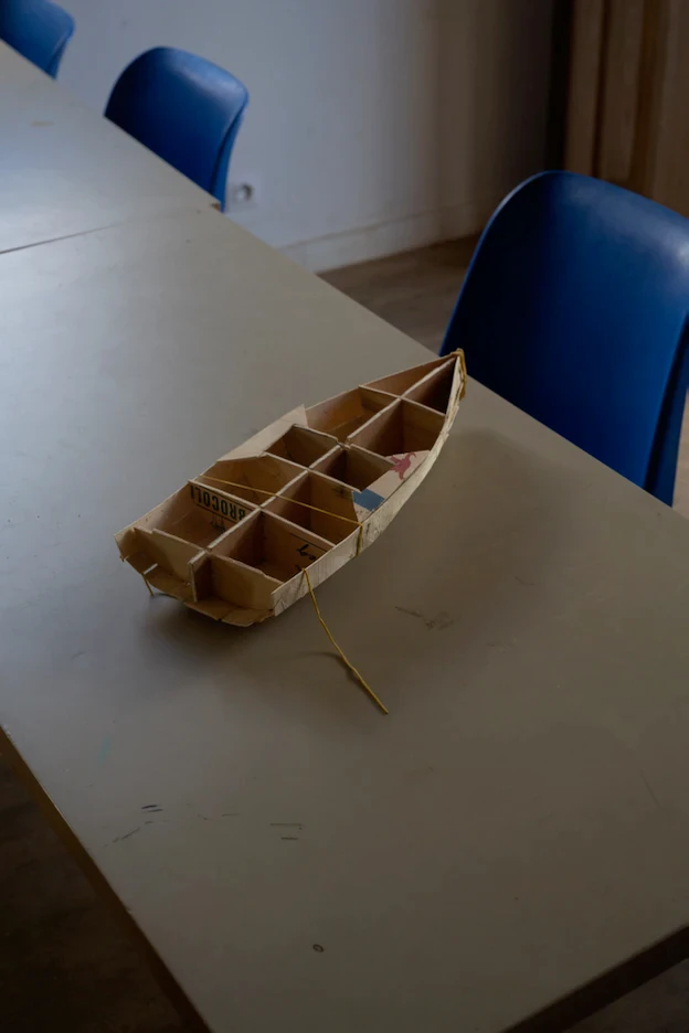 Petite maquette de bateau en bois posée sur un bureau