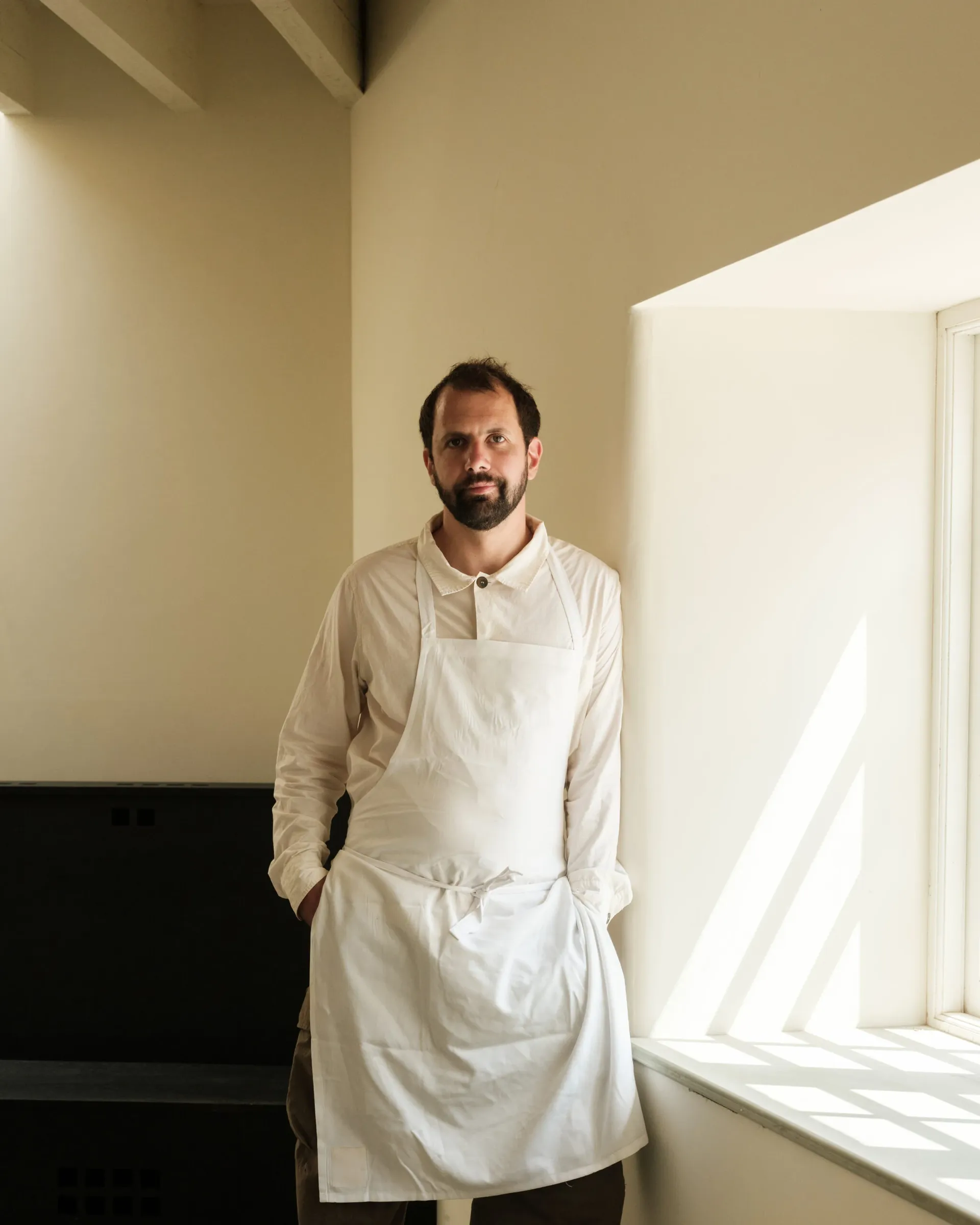 Le chef Merlin Labron Johson pose avec son tablier de cuisine blanc immaculé
