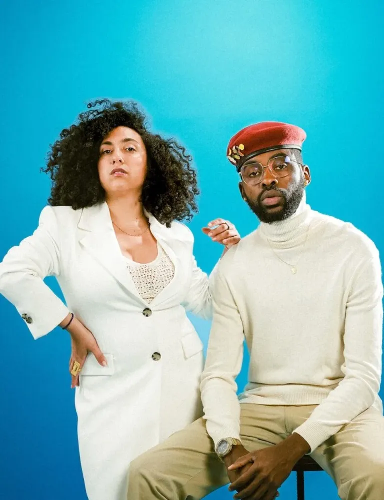 Les artistes NouN & T2i posent ensemble devant un fond bleu