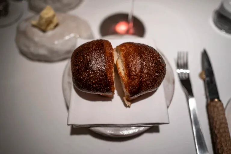 Petit pain posé sur une assiette et une serviette blanche au restaurant Osip