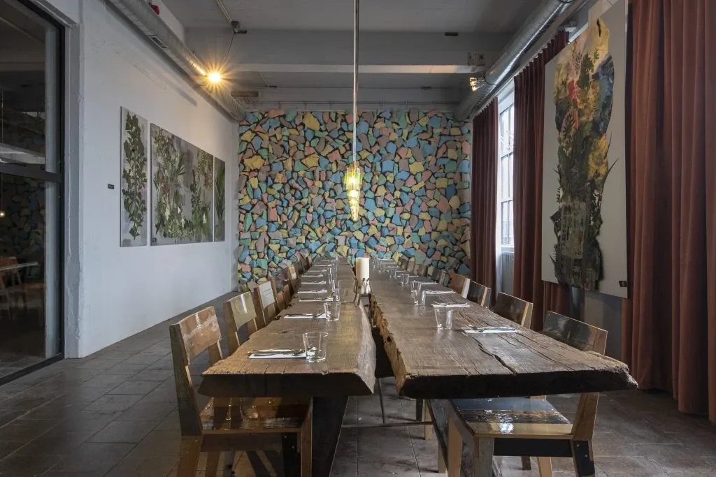 Table et chaises en bois massif recyclé par le designer Piet Hein Eek dans une salle à manger d'hôtel