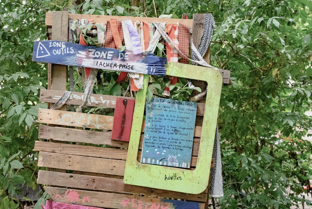 Structure en bois avec disposé dessus un tableau en ardoise précisant des principes du lieu