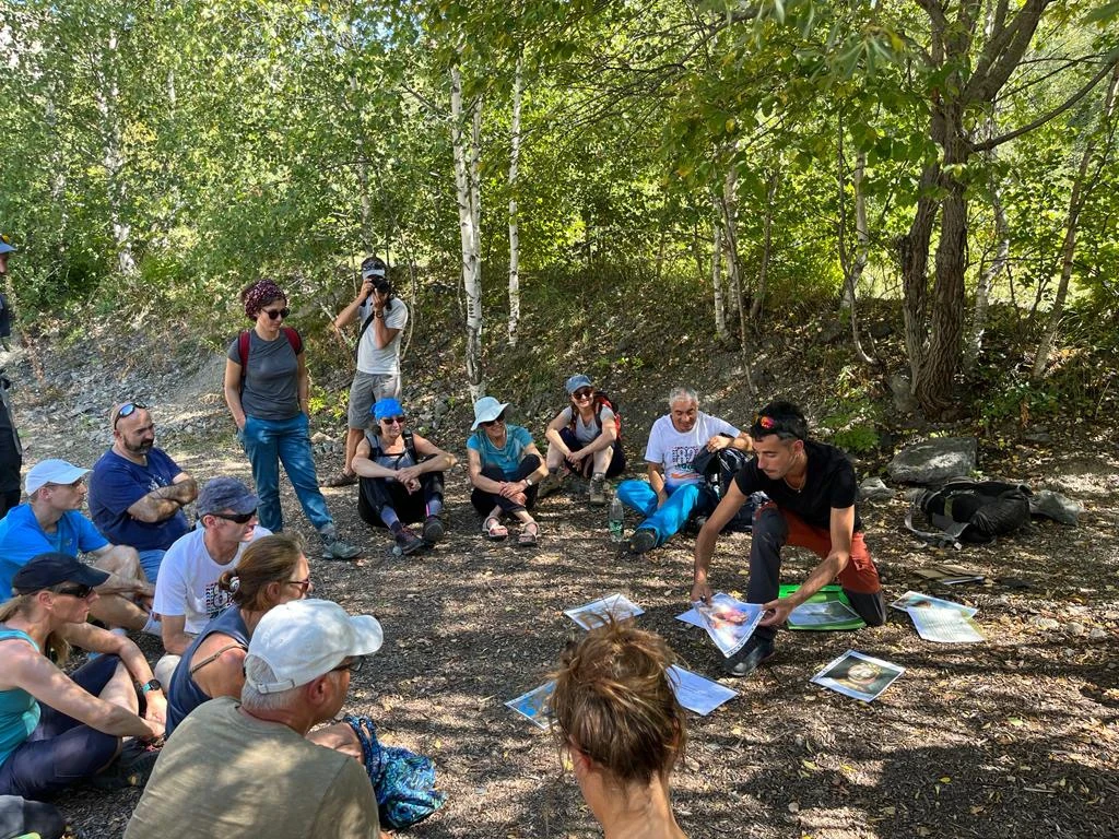 Randonneurs assis en cercle devant un animateur discutant philosophie 