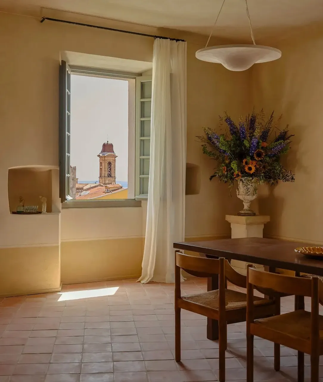 Grande suite de l'Hôtel du Couvent avec vue sur le clocher et une table en bois